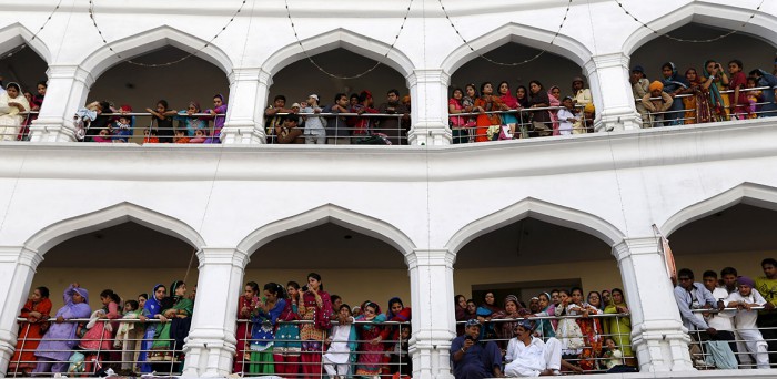 Sikh devotees watch the Vaisakhi festival procession at Panja Sahib shrine(Caren Firouz-Reuters) (82K)
